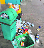 Garbage scattered around dustbins.