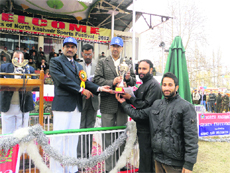 Minister of State for Home Nasir Aslam Wani gives away a trophy to participants in Baramulla on Saturday.
