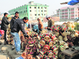  A Kashmiri roadside vendor sells traditional fire pots, Kangris, in Srinagar on Saturday. Ahead of harsh winter, people are buying fire pots made up of clay and twigs. 