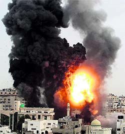 An explosion and smoke are seen after Israeli strikes in Gaza City on Friday