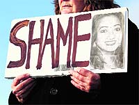 A woman holds a picture of Savita Halappanavar in protest outside in Galway