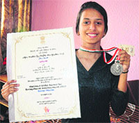 Aishna shows her medal and certificates at her residence in Sector 40, Chandigarh, on Sunday.