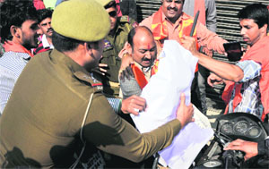 policemen try to take away an effigy from the activists in Jammu on Sunday