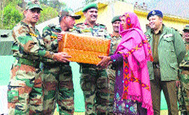 Army personnel give a gift to a woman at a rally in Samote.