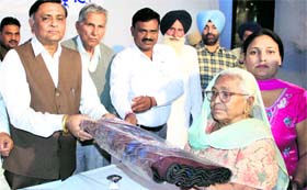 MLA Manoranjan Kalia distributes blankets among the underprivileged at a school during a function organised by Punjab Kalyan Charitable Trust in Jalandhar on Sunday.