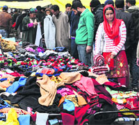 People buy woollens at a market in Srinagar on Sunday. 