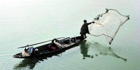 A fisherman casts his net in the Jhelum in Srinagar on Sunday.