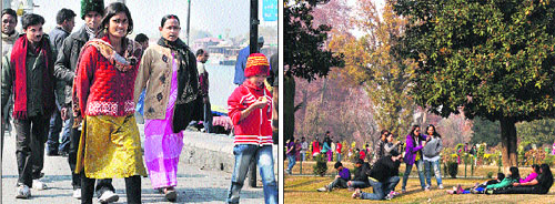 Tourists take a walk on the banks of the Dal Lake and (right) a group of youngsters enjoy the autumn season at Nishat garden in Srinagar on Sunday.