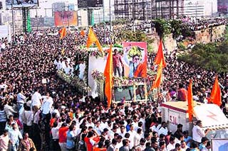 Shiv Sena supporters crowd around the vehicle carrying the body of Bal Thackeray during his funeral procession in Mumbai on Sunday