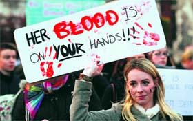 A woman holds a poster during a vigil in memory of Savita Halappanavar and in support of changes to Irelands abortion laws in Dublin.