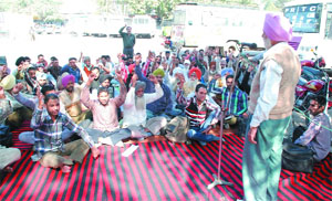 Contractual employees staging a dharna at the PRTC workshop situated on the premises of bus stand in Bathinda on Tuesday.