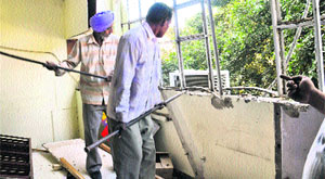 Estate Office employees demolish an illegal structure at Sector 17, Chadigarh, on Monday.