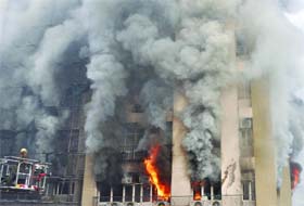 A firefighter tries to douse the fire that broke out in Himalaya House at Kasturba Gandhi Marg in New Delhi on Monday