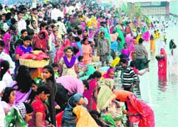 Devotees perform rituals during Chhath puja at Braham Sarovar in Kurukshetra on Monday.