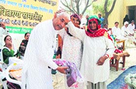 An elderly woman blesses Raj Kumar Ridhau during the Varishth Nagrik Samman Samaroh organised by the Swatantrata Sainani Daya Singh Memorial Trust at Ridhau village.