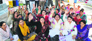 Members of the Jammu Kashmir Female Multipurpose Health Workers Welfare Association hold a demonstration in Jammu on Monday. 
