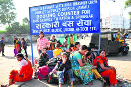 Passengers wait outside the railway station in Jammu on Monday as transporters go on a strike in the state.