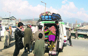 Passengers board a vehicle for going to Karnah near Kupwara bus stand. 