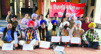 Members of the PAU Employees Union stage a protest at the PAU in Ludhiana on Monday.