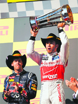 McLarens Lewis Hamilton trumps Red Bulls Sebastian Vettel to lift the U.S. Grand Prix trophy on Monday; Hamilton (top right) sports a Cowboy hat with a grin at the podium.