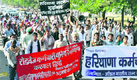 Government employees stage a demonstration in Karnal on Tuesday.