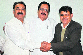Independent candidate Rajinder Kumar Sharma (left) withdraws his nomination for Congress candidate Sham Lal Bhagat (right) during a press conference in Jammu on Tuesday.