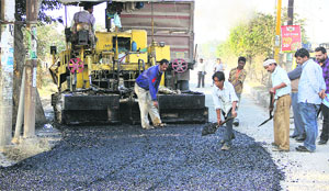 Potholed Garha road being re-laid in Jalandhar on Tuesday. 