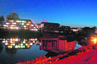 A house boat moored to the bank of the Jhelum is illuminated with floodlights in Srinagar on Tuesday. 