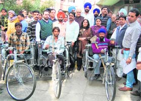 Senior BJP leader Balbir Punj and MP Navjot Singh Sidhu distribute tricycles among physically challenged persons at the Jallianwalla Bagh Memorial Civil Hospital in Amritsar on Wednesday