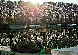 A man rests on the parapet of the Dal lake in Srinagar