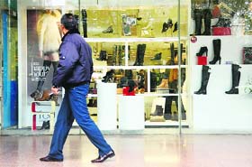 A man walks past a shoe store in Beijing. China's manufacturing activity grew in November for the first time in 13 months, HSBC said Thursday, in a further sign of strengthening of the world's second-largest economy after a marked slowdown