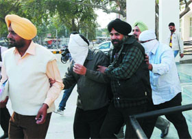 Vigilance Bureau sleuths take away the accused after securing their two-day remand from a court in Bathinda on Thursday.