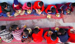 Schoolchildren partake a meal under the Mid Day Meal Scheme at Government Primary School in Jammu. A Tribune photograph