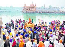 Sikh devotees carry a palanquin having Guru Granth Sahib in a nagar kirtan at the parikarma of the Golden Temple on the eve of the martyrdom day of Guru Teg Bahadur in Amritsar on Friday