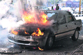 A Ford Escort that caught fire on the road separating Sectors 20 and 21 in Chandigarh on Friday.