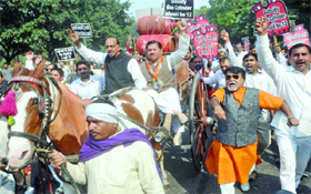 BJP activists led by party leader Vijay Goel drive a tonga full of gas cylinders during a demonstration outside Delhi Chief Minister Sheila Dikshit's residence in New Delhi on Friday, demanding that gas cylinders should be increased to 12 from six a year for their domestic usage.
