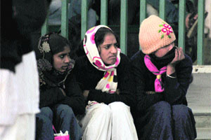 Girls wrapped in woollens in Shimla on Friday. 