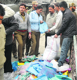 Municipal Corporation officials along with seized polythene in Srinagar on Friday.