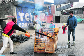 A man burns a wooden box to make charcoal in Srinagar on Friday.