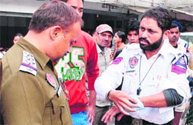 The injured traffic cop shows his injuries to a policeman in Amritsar on Saturday