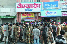 Cops close the main gate of the Teachers Home to prevent the unaided school staff from going out and burning an effigy of the state government on Saturday.