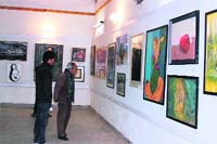 Visitors have a look at photos at an art exhibition in Almora on Saturday.