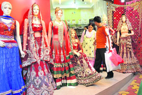 Shoppers check out bridal lehnga at a shop in Jammu on Saturday.