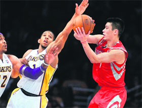 The picture shows Houston Rockets point guard Jeremy Lin (R) making a pass inside as Los Angeles Lakers centre Dwight Howard (L) and Lakers point guard Darius Morris (1) defend during the second half of their NBA basketball game in Los Angeles, California.