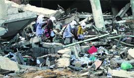 Palestinian schoolgirls walk on the rubble of a building destroyed during Israeli bombardment as they make their way to their school in Gaza City on Saturday.