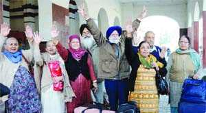 Devotees wave to their relatives before leaving for a pilgrimage to Pakistan, at Amritsar on Sunday. 