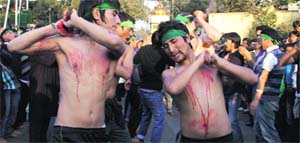 Members of the Shia community flagellate themselves with iron chains during a Moharram procession in Dehradun on Sunday. 