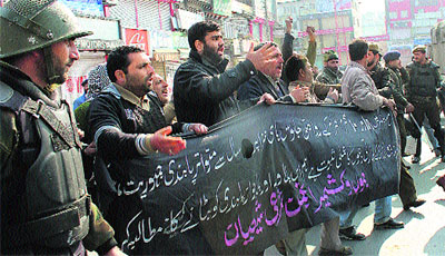 Police personnel stop activists of the Jammu and Kashmir Anjuman-e-Shari during a protest in Srinagar on Sunday.