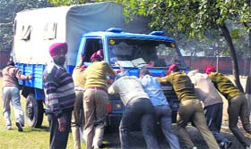 Policemen at the PAP Complex in Jalandhar push back a goods carrier in an effort to start the vehicle.