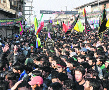 People of Shiite faith attend a mourning during a Muharram procession in downtown Srinagar on Sunday